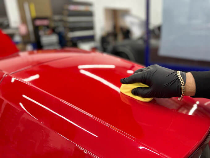 Técnico certificado de Polar Tint Henderson aplicando recubrimiento cerámico 3M sobre película de protección de pintura en un vehículo de lujo